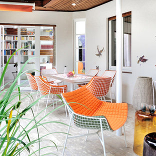 Großer Mid-Century Patio hinter dem Haus mit Markisen, Kübelpflanzen und Betonplatten in München