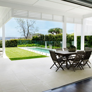This is an example of a mid-sized beach style backyard patio in Sydney with a roof extension and an outdoor kitchen.
