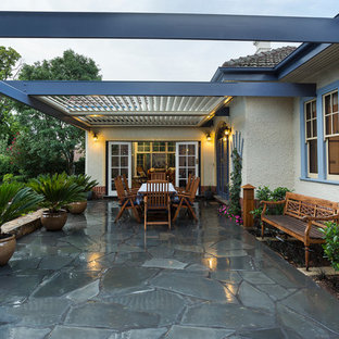 Immagine di un grande patio o portico stile americano dietro casa con pavimentazioni in pietra naturale e una pergola