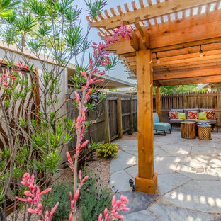 Patio - mid-sized southwestern backyard stone patio idea in Dallas with a pergola