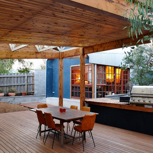 Idee per un patio o portico industriale dietro casa con pedane e un tetto a sbalzo