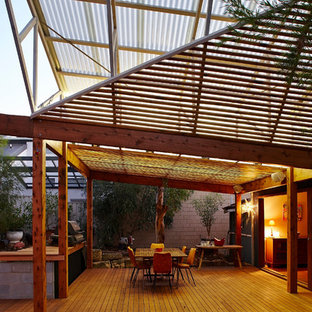 Foto di un patio o portico industriale dietro casa con pedane e un tetto a sbalzo