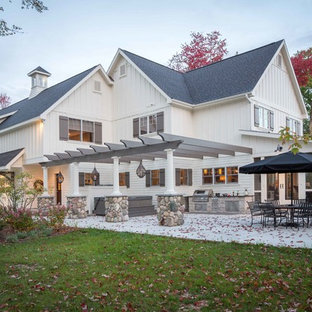 Immagine di un grande patio o portico classico dietro casa con lastre di cemento e una pergola