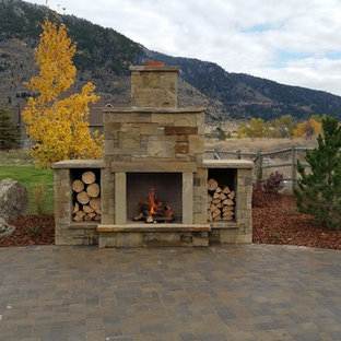 Idee per un grande patio o portico stile rurale dietro casa con un focolare, pavimentazioni in pietra naturale e nessuna copertura