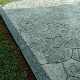 Immagine di un grande patio o portico classico dietro casa con un focolare, cemento stampato e nessuna copertura