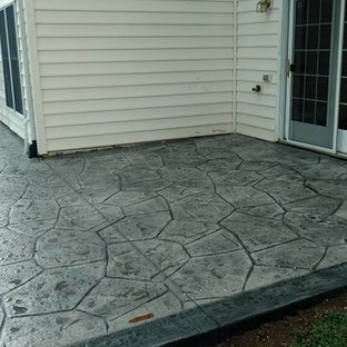 Immagine di un grande patio o portico tradizionale dietro casa con un focolare, cemento stampato e nessuna copertura