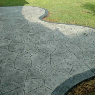 Ispirazione per un grande patio o portico chic dietro casa con un focolare, cemento stampato e nessuna copertura