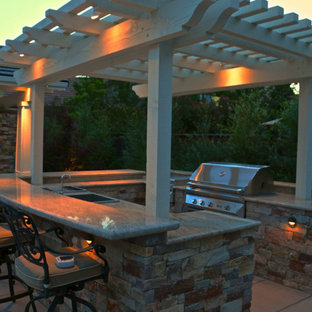 Ispirazione per un grande patio o portico stile americano dietro casa con pavimentazioni in cemento e una pergola