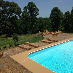 Immagine di un grande patio o portico rustico dietro casa con un focolare, pavimentazioni in pietra naturale e nessuna copertura