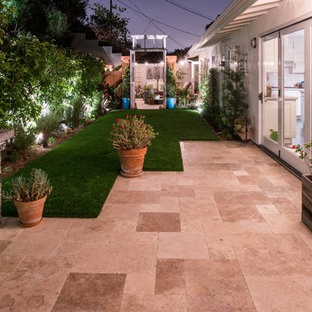 Idee per un patio o portico design di medie dimensioni e dietro casa con un focolare, piastrelle e una pergola