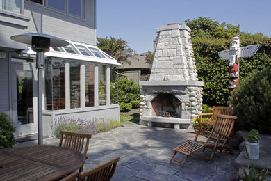 Ejemplo de patio contemporáneo sin cubierta en patio delantero con brasero y adoquines de piedra natural