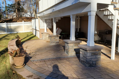 Patio - large contemporary backyard brick patio idea in Newark with no cover