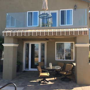 Inspiration for a mid-sized timeless backyard patio remodel in Orange County with a roof extension