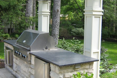 Patio kitchen - large modern backyard concrete paver patio kitchen idea in Toronto with a pergola