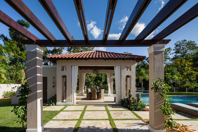 Foto de patio mediterráneo grande en patio trasero con pérgola, cocina exterior y adoquines de piedra natural