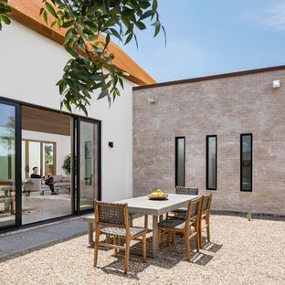 Esempio di un patio o portico stile americano in cortile con un focolare, graniglia di granito e nessuna copertura