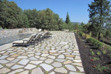 Inspiration for a large timeless backyard stone patio remodel in Other