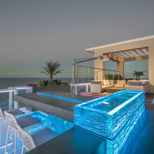 Huge minimalist backyard patio photo in Miami with a fire pit and no cover
