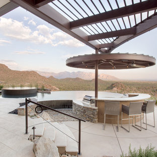 Ispirazione per un grande patio o portico design dietro casa con pavimentazioni in mattoni e una pergola