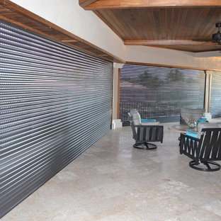 Foto di un grande patio o portico tropicale dietro casa con piastrelle e un tetto a sbalzo