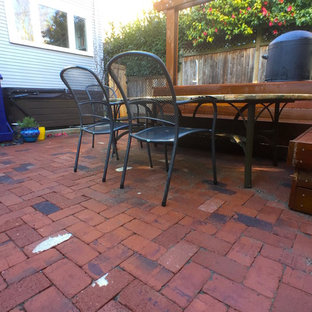 Ispirazione per un patio o portico eclettico di medie dimensioni e dietro casa con pavimentazioni in mattoni e una pergola