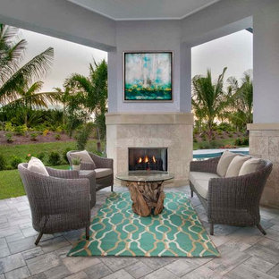 Immagine di un grande patio o portico stile marinaro dietro casa con un tetto a sbalzo, pavimentazioni in pietra naturale e un caminetto