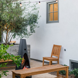 Foto di un patio o portico design di medie dimensioni e dietro casa con un focolare, graniglia di granito e nessuna copertura