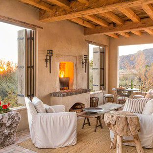 Idee per un patio o portico stile americano con un focolare, pavimentazioni in mattoni e un tetto a sbalzo