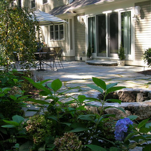 Idee per un piccolo patio o portico classico dietro casa con un focolare, pavimentazioni in pietra naturale e nessuna copertura