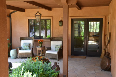Réalisation d'une terrasse arrière tradition de taille moyenne avec des pavés en pierre naturelle et une extension de toiture.