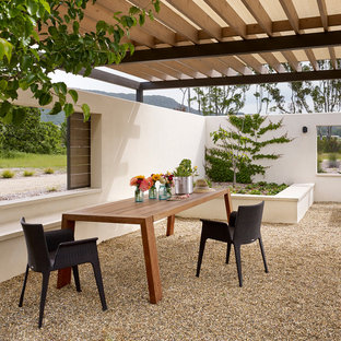 Esempio di un patio o portico country con ghiaia e una pergola