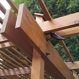 Esempio di un grande patio o portico etnico dietro casa con fontane, cemento stampato e una pergola