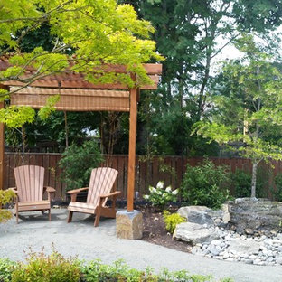 Immagine di un grande patio o portico etnico dietro casa con fontane, una pergola e cemento stampato