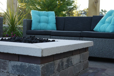 Example of a mid-sized trendy backyard concrete paver patio design in Other with a fire pit and a pergola