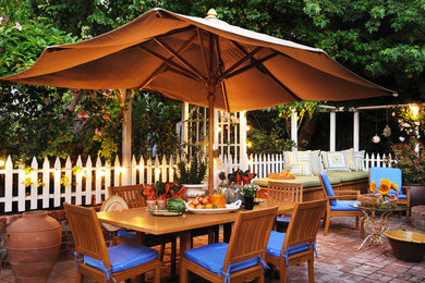 Diseño de patio tradicional de tamaño medio en patio trasero con adoquines de ladrillo y cenador