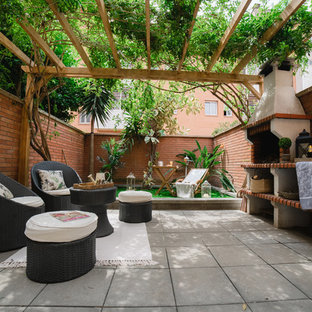 Imagen de patio clásico renovado con cocina exterior, adoquines de hormigón y cenador