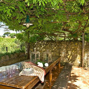 Idée de décoration pour une terrasse avant champêtre avec des pavés en brique et une pergola.