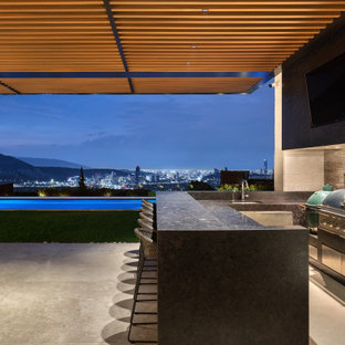 Immagine di un grande patio o portico contemporaneo dietro casa con un tetto a sbalzo