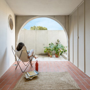 Ejemplo de patio mediterráneo, en anexo de casas, con suelo de baldosas