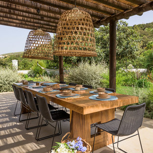 Esempio di un grande patio o portico tropicale con una pergola