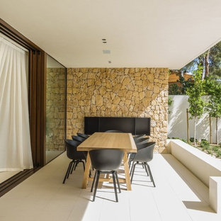 Modelo de patio mediterráneo, en anexo de casas, con chimenea y suelo de baldosas