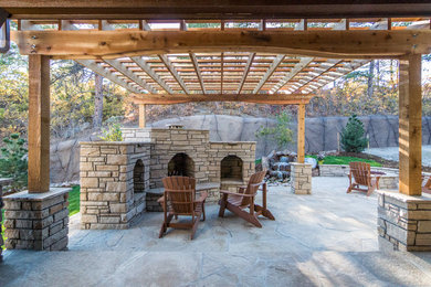 Inspiration for a large rustic backyard stone patio remodel in Denver with a fire pit and a pergola