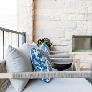 Immagine di un patio o portico minimal di medie dimensioni e dietro casa con un caminetto e un tetto a sbalzo