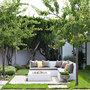Idee per un patio o portico costiero dietro casa con un focolare, pavimentazioni in cemento e nessuna copertura