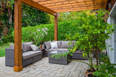 Patio - mid-sized contemporary backyard stone patio idea in Toronto with a pergola
