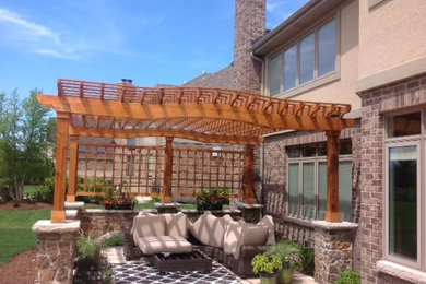 Transitional backyard stone patio photo in Chicago with a pergola