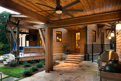 Patio - mid-sized craftsman backyard stone patio idea in Atlanta with a roof extension