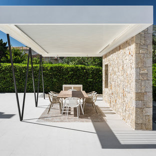 Imagen de patio mediterráneo, grande, en patio delantero, con losas de hormigón y pérgola