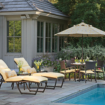 Chaise lounges, outdoor wicker chairs and aluminum table with patio umbrella