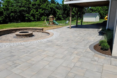 Example of a large transitional backyard concrete paver patio design in Philadelphia with a fire pit and no cover